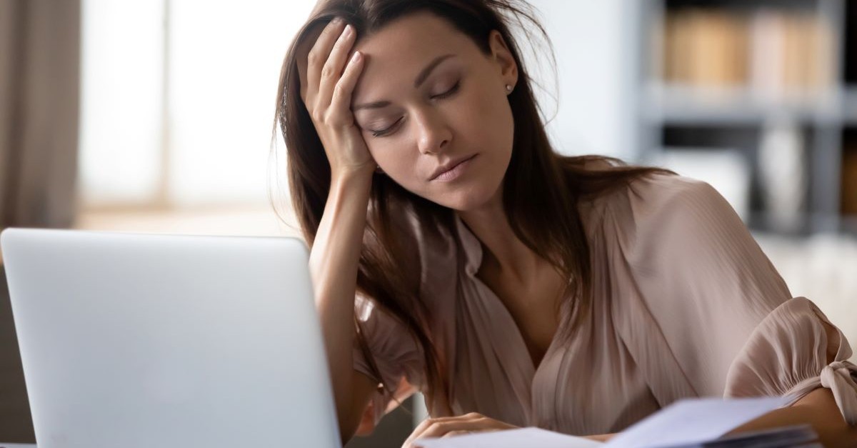 Girl at computer tired burnt out exhausted overworked; idolizing ministry work is a sneaky sin overlooked by Christians.