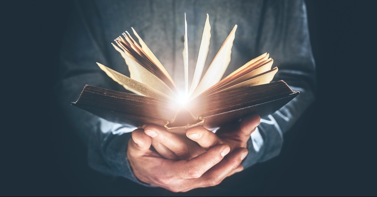 Bible glowing in a man's hands