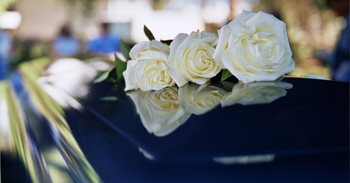 a flower on a coffin, John Baker passes away