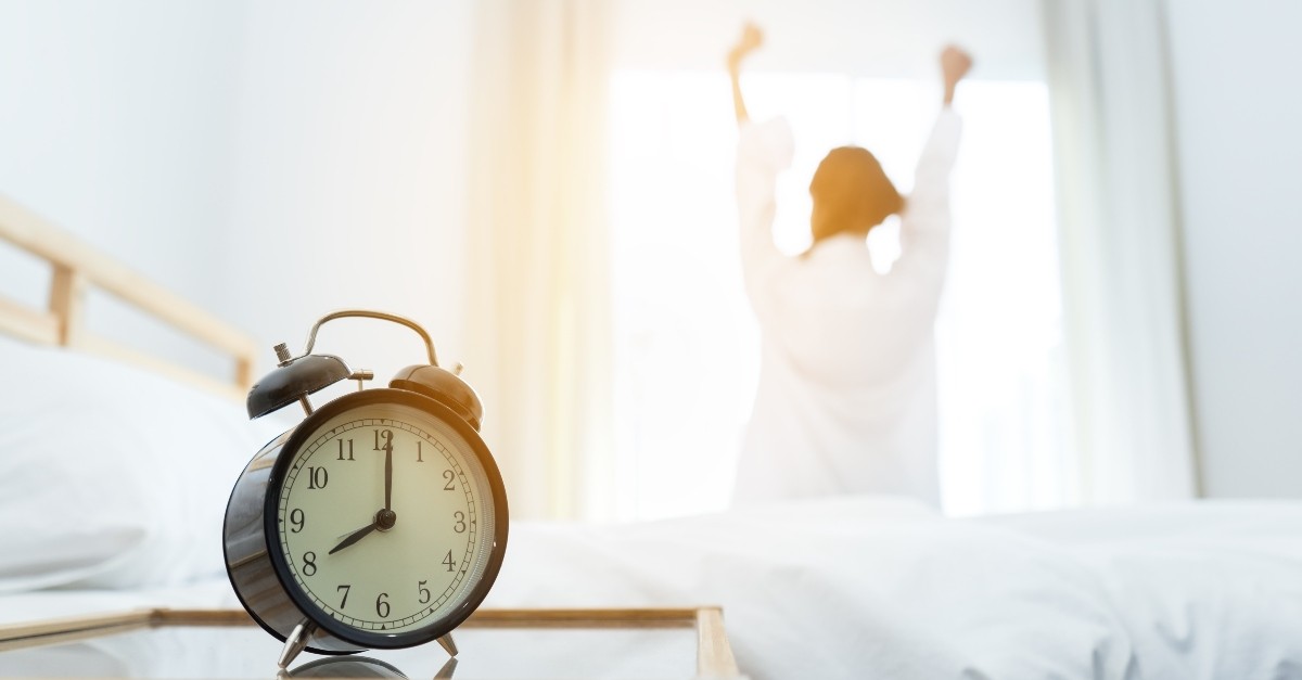 Woman stretching in front of the window with the morning sun