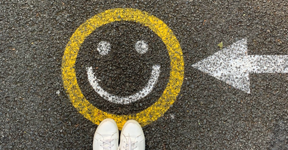 A smiling face drawn on the pavement, Americans are more optimistic than they have been in 15 years