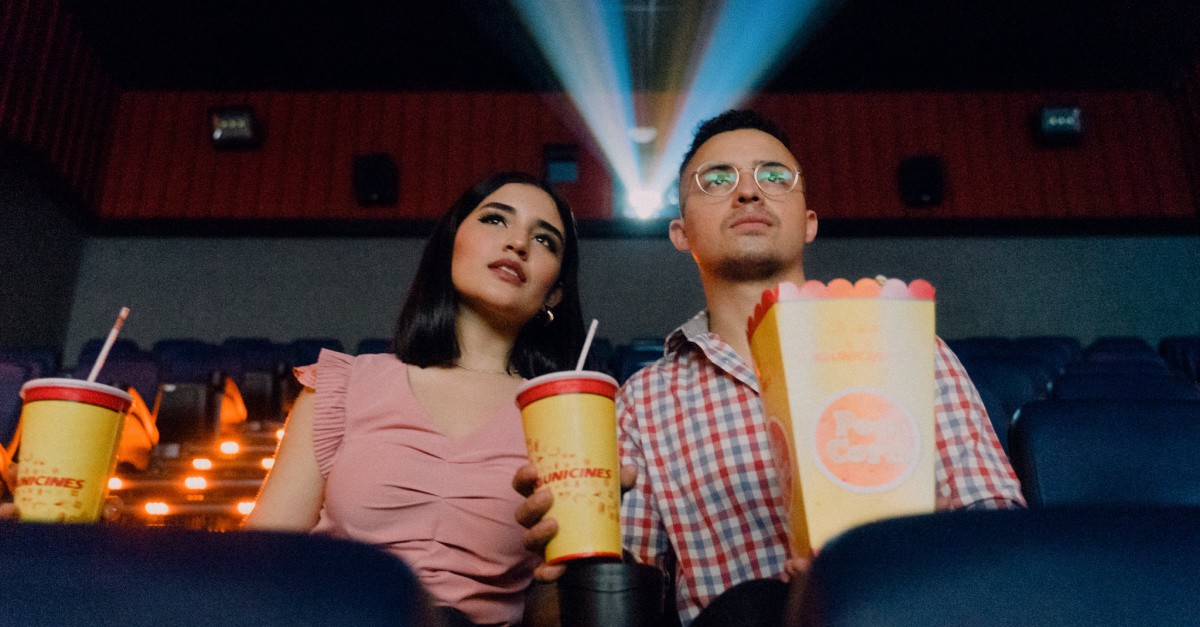 A man and a woman watching a movie in a theater, movies you should watch this summer