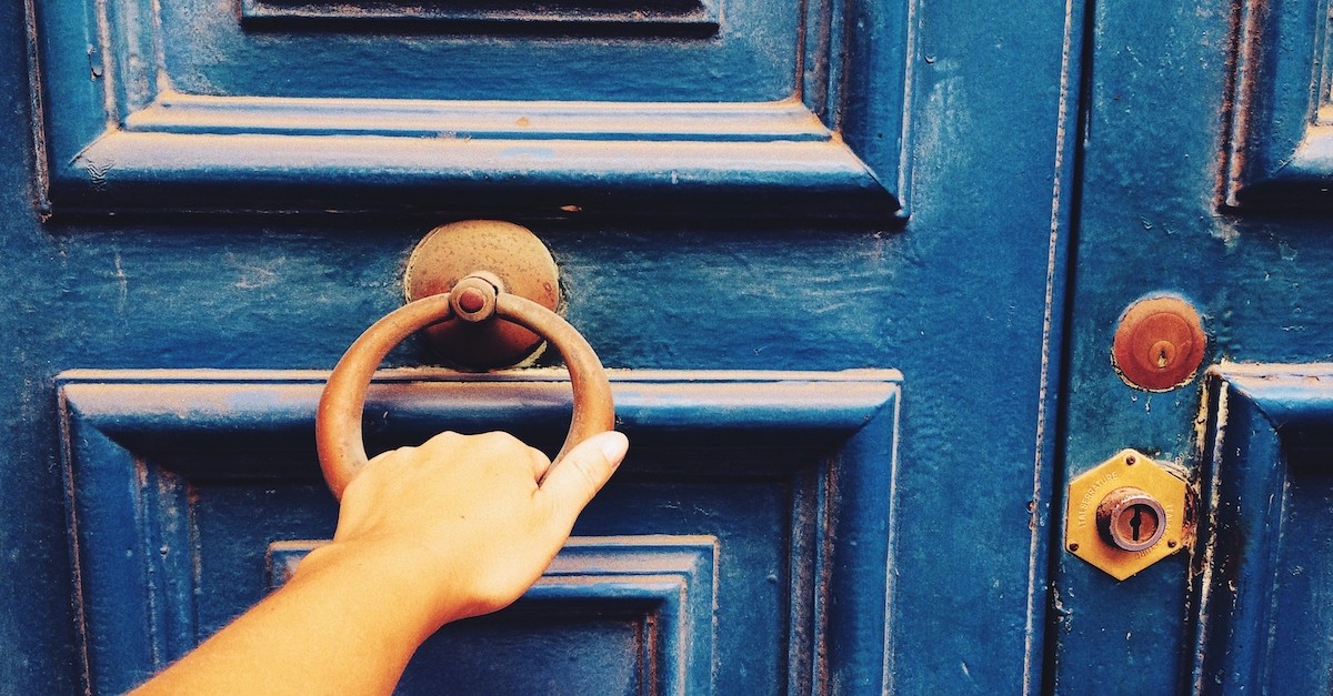 woman's hand pulling door handle on closed locked door, depart from me