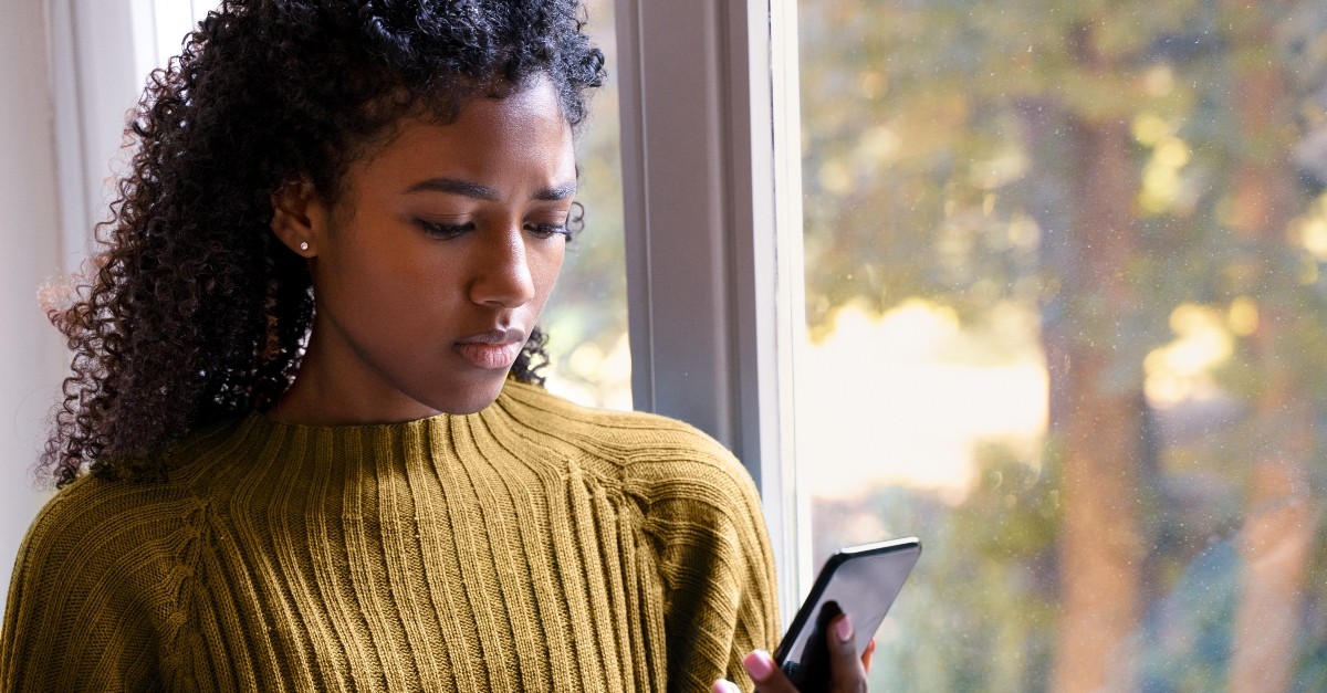 Woman looking at her phone; is comparison a sign of covetousness?