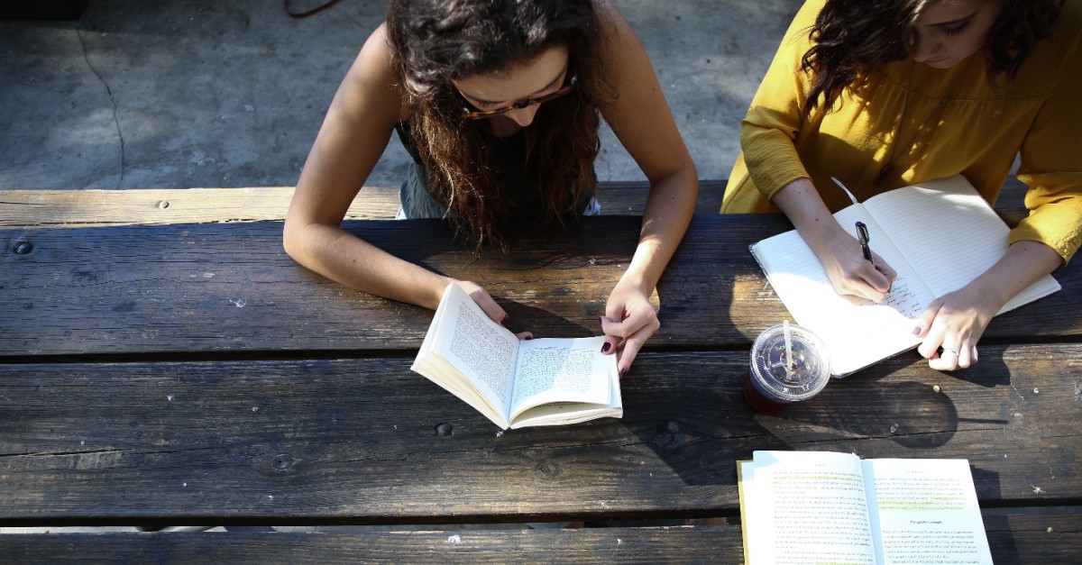 Girl reading at a table, mere christianity by cs lewis