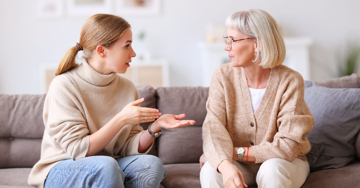 Mother and daughter looking confused on a couch