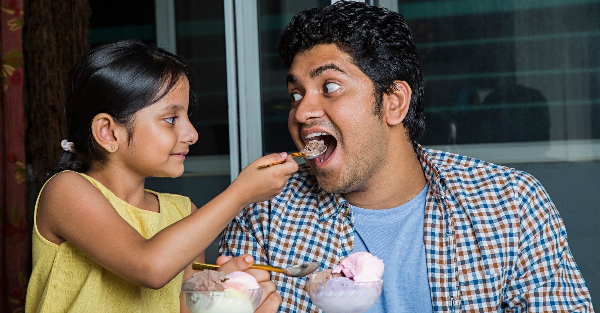 dad and daughter eating ice cream having fun