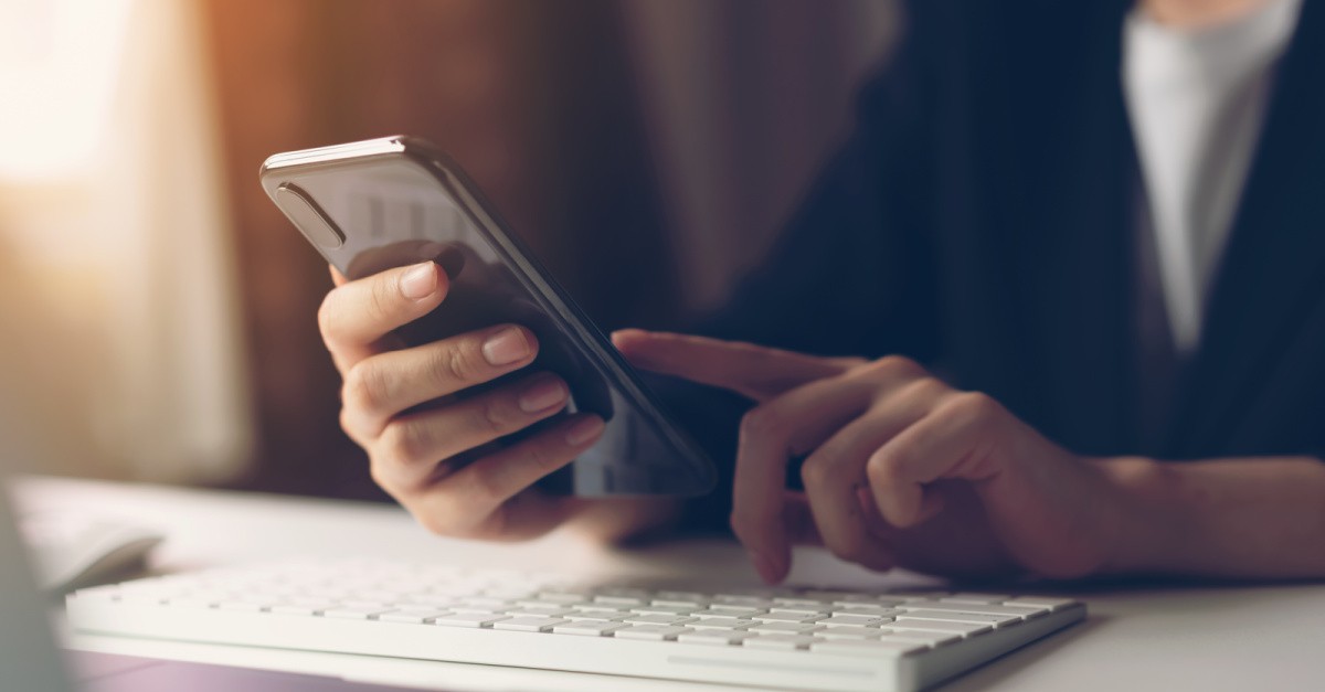 a person holding a phone, reading news to stay informed defy worldly labels and show your faith