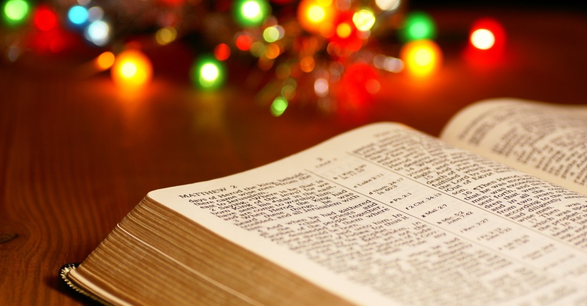 Open Bible next to Christmas lights
