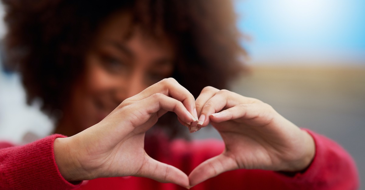woman making shape of heart with hands