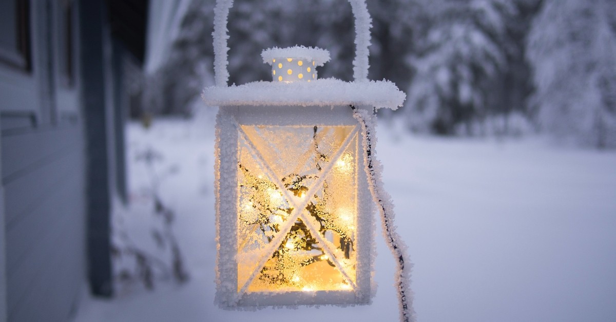 Brightly lit lantern covered in snow