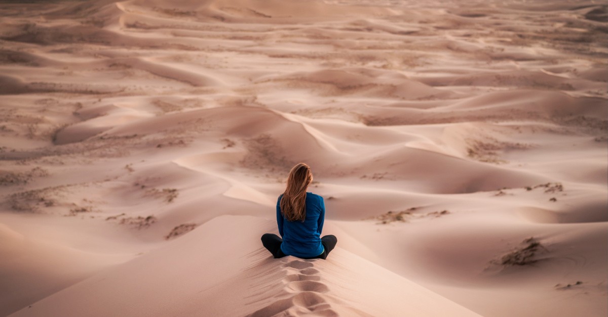 woman sitting in a desert, a guide for those in a Spiritual desert