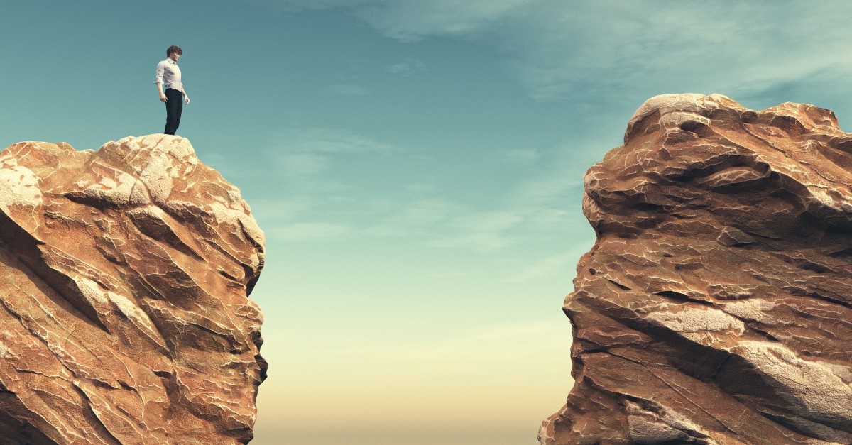 Man standing on a cliff looking at a gap