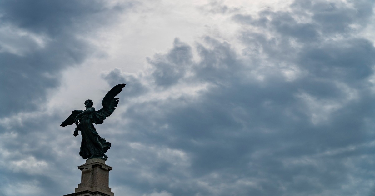 Statue of an angel on a cloudy day