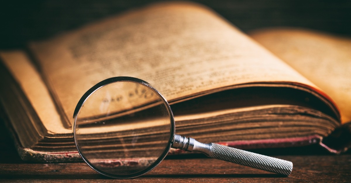 Old manuscript and magnifying glass