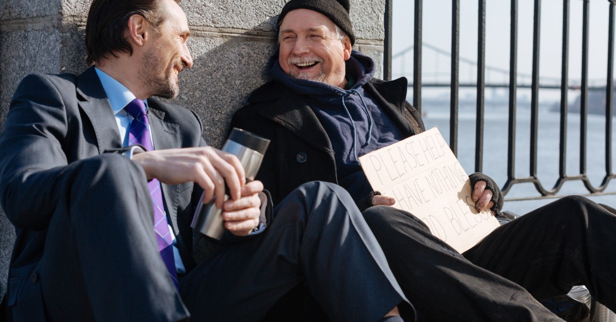 business man talking and laughing with homeless man