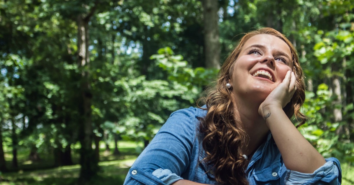 Happy woman looking up; what is the purpose of life?