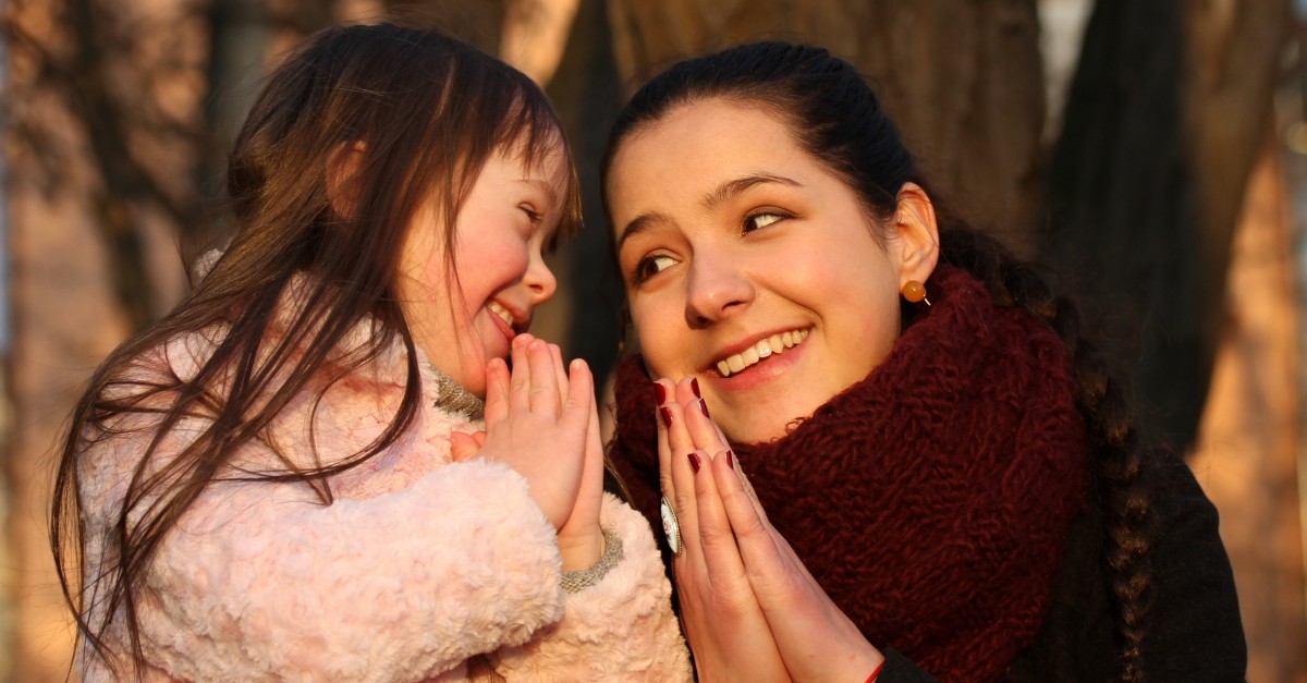 mom praying with special needs daughter