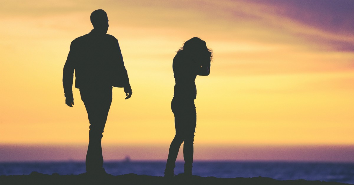 silhouette of couple looking upset husband walking toward distressed woman, what should a woman do when a husband is cruel