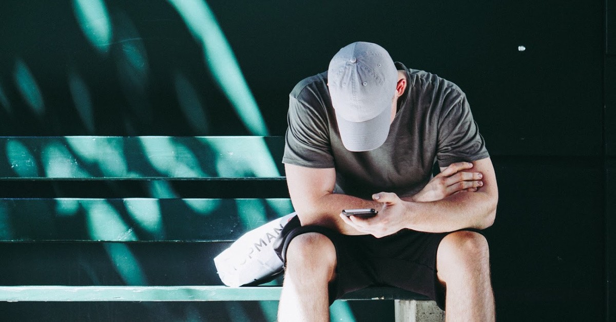 Man looking at his phone; is ok for Christians to use dating apps?