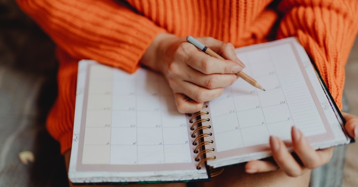 woman writing in calendar planner