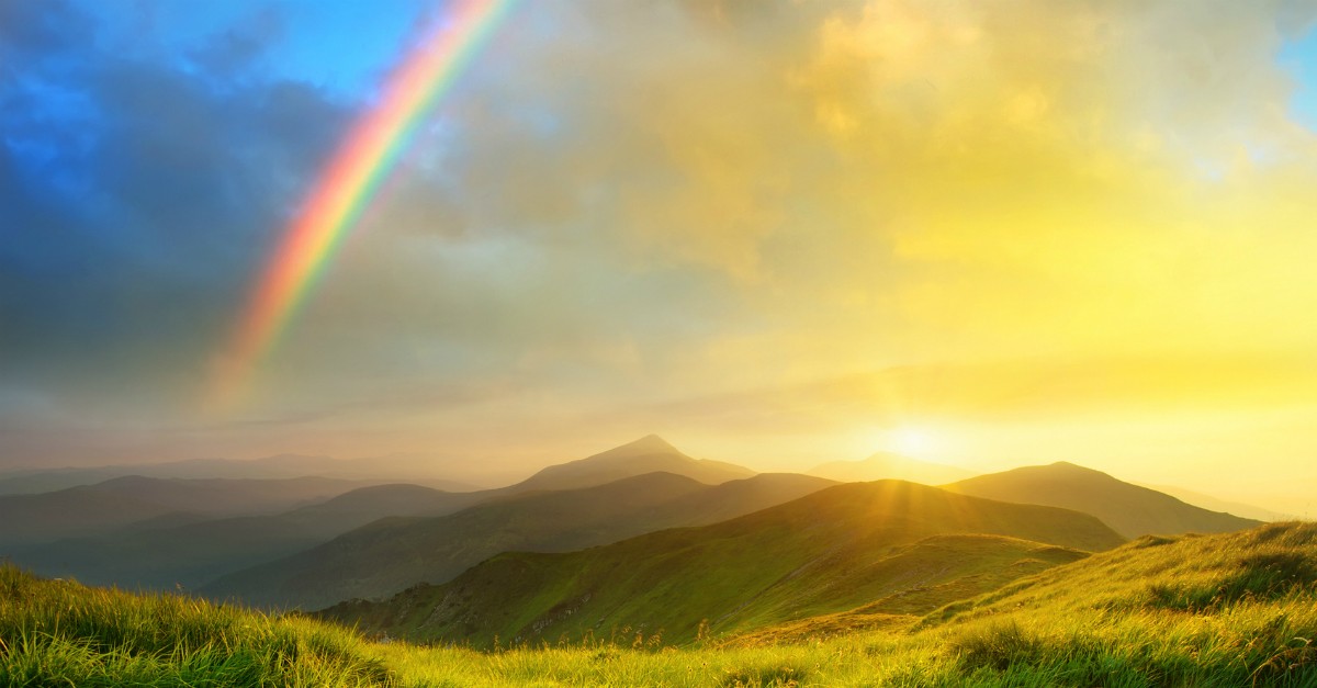 gorgeous nature landscape with rainbow and sunrise over mountains and valley