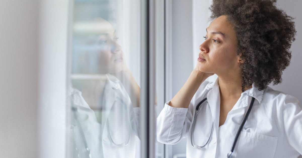 tired woman doctor leaning on window