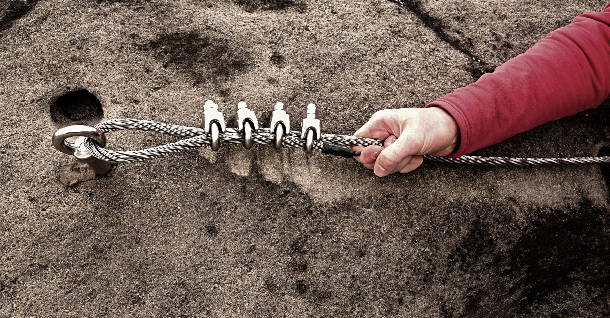 Man securing a rope to rock climb