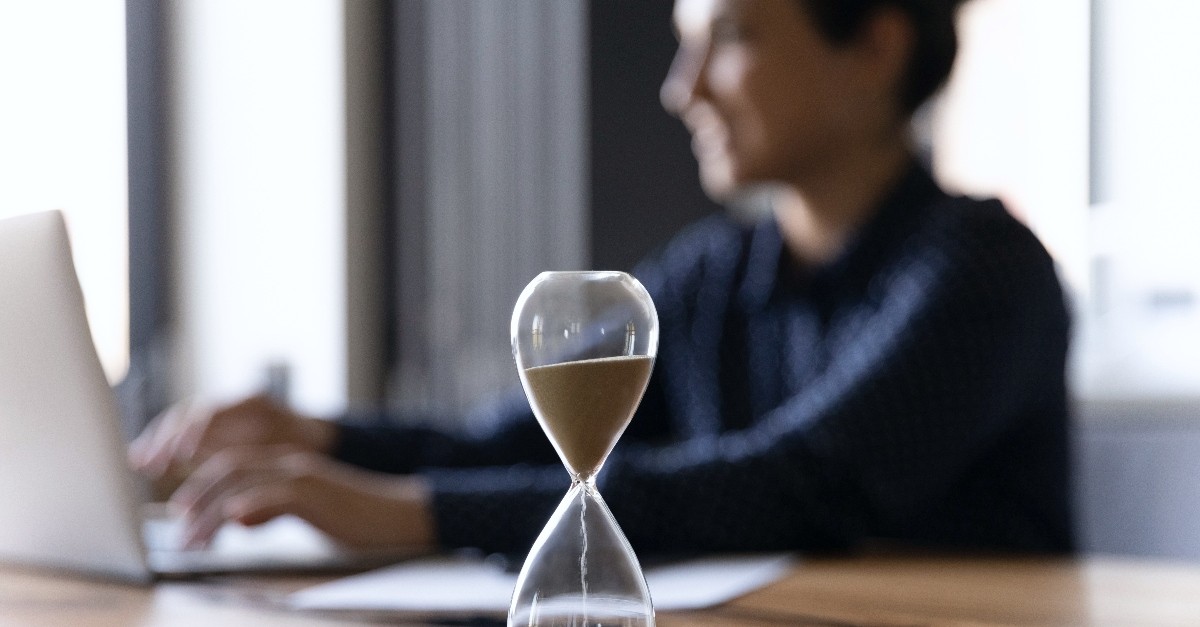 Woman working by an hour glass