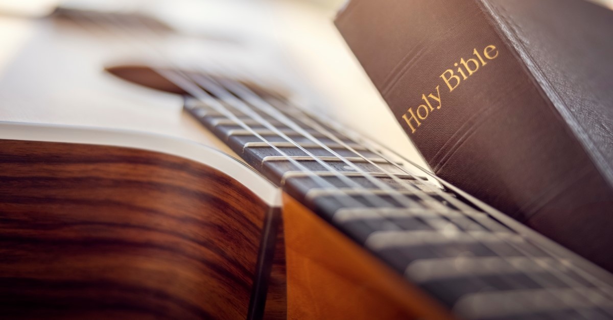 guitar with holy bible lying on top of it, christian music