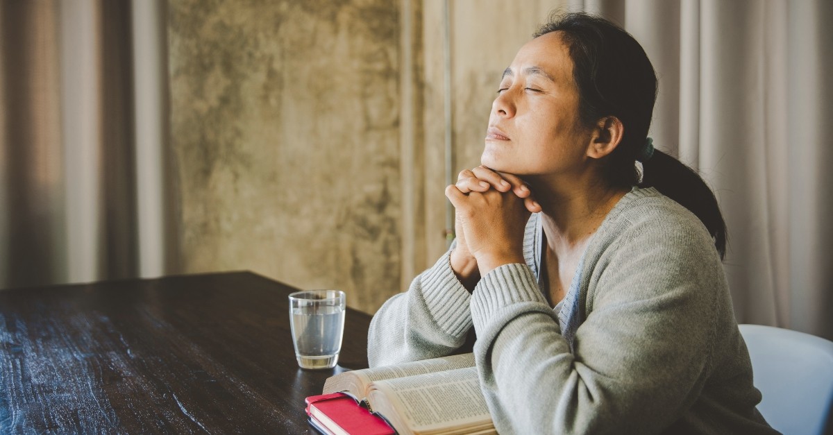 Woman praying over her Bible