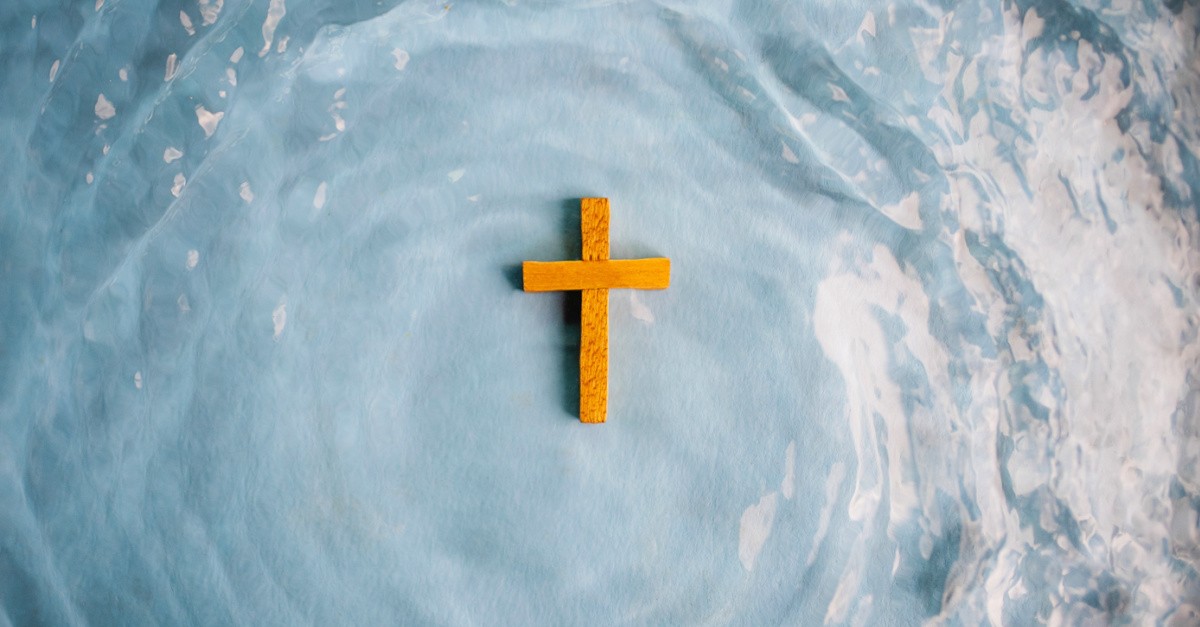 Wooden cross floating on top of the water. 