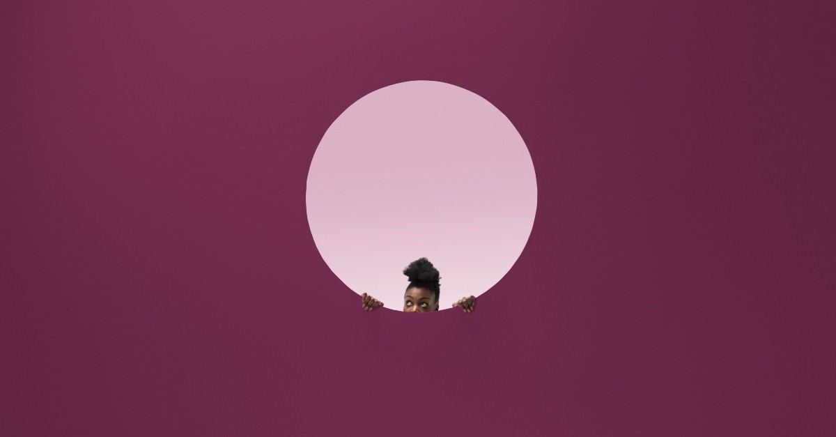 Woman peeking out of a hole in a purple wall; what is the sin of sloth?