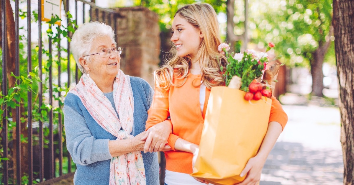 Young woman helping elderly neighbor