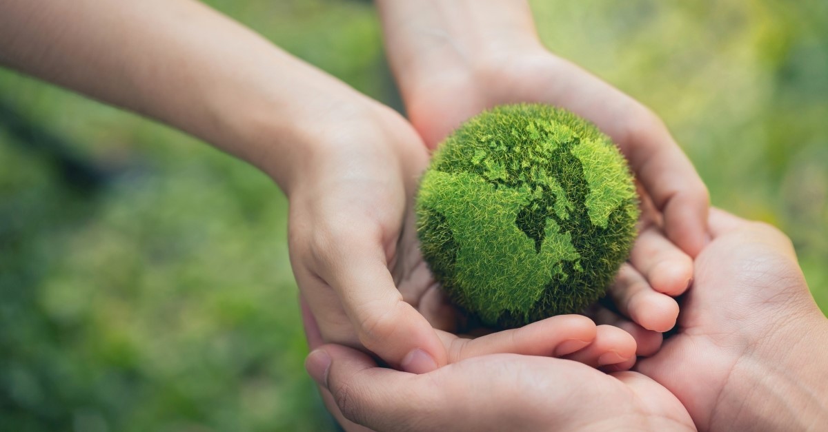 hands holding a green earth, beginning of Earth Day