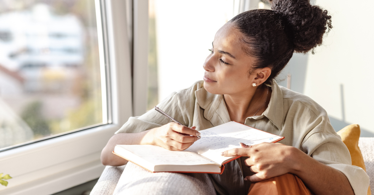 Woman sitting by a window, journaling; 2 Things I Do to Support My Mental Health