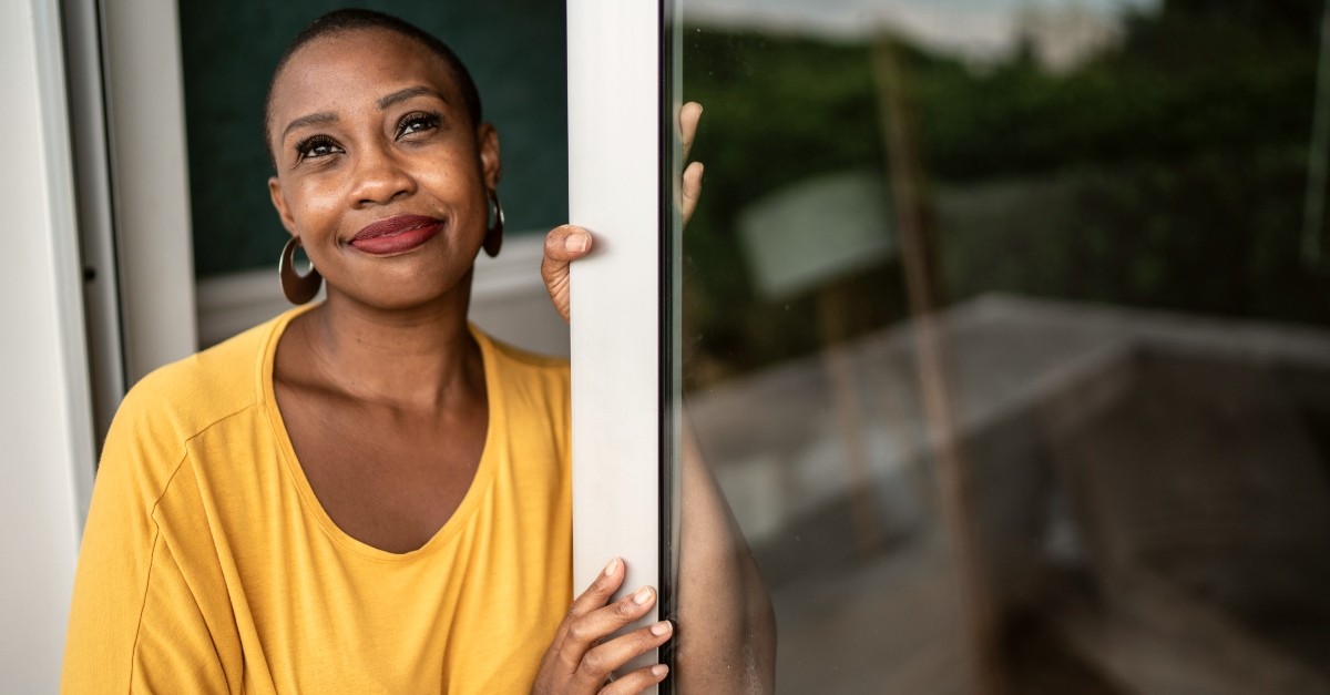 Woman looking up at the sky from her home