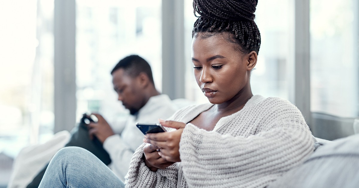 Couple on couch distracted on phones