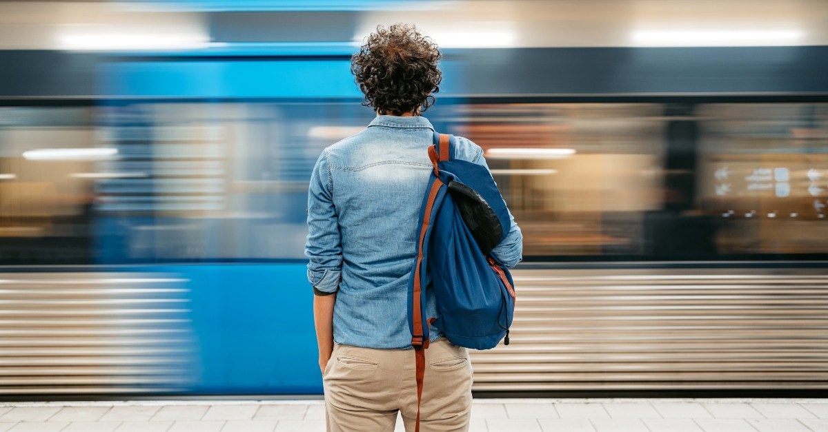 Man watching a blurry subway go by