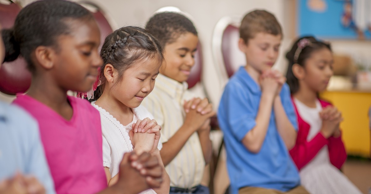 diverse group of young children praying