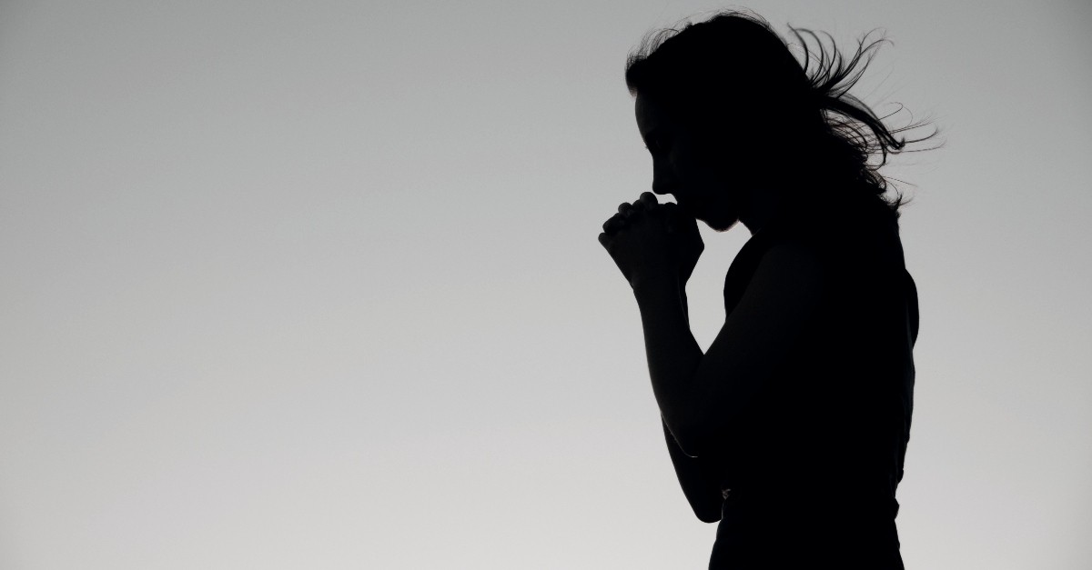 Woman praying; sexual immorality is a sin ofter overlooked in Christian ministry. 