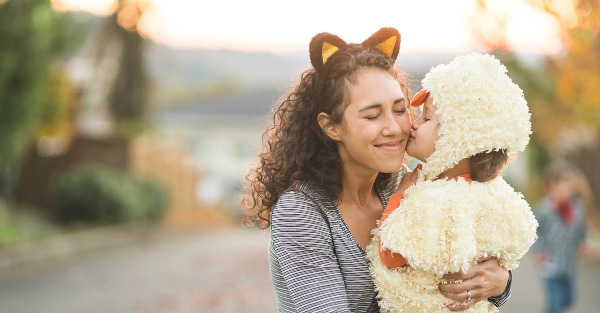 toddler trick or treating kissing mom on halloween