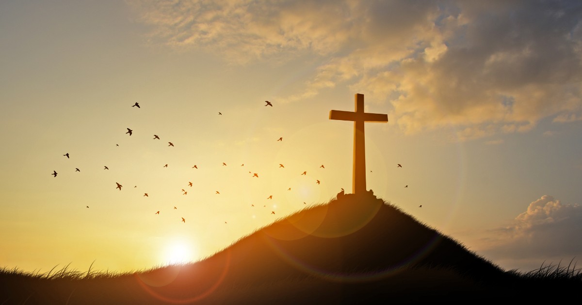 Cross on a Hill with a Sunrise in Background