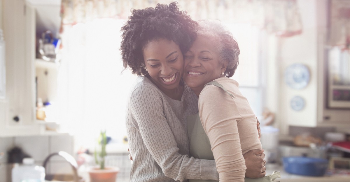 older mother and daughter hugging at thanksgiving