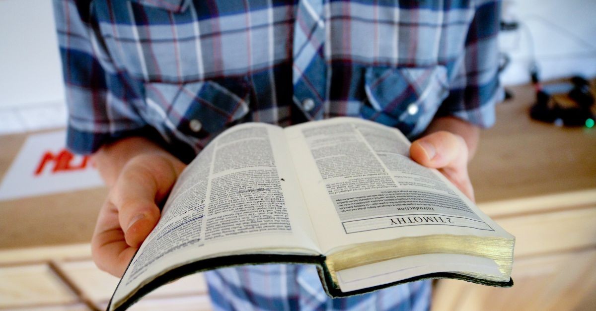 Person holding an open Bible