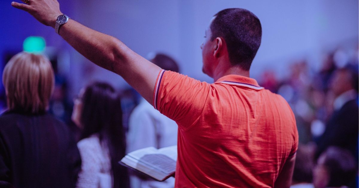 Man in worship holding an open Bible