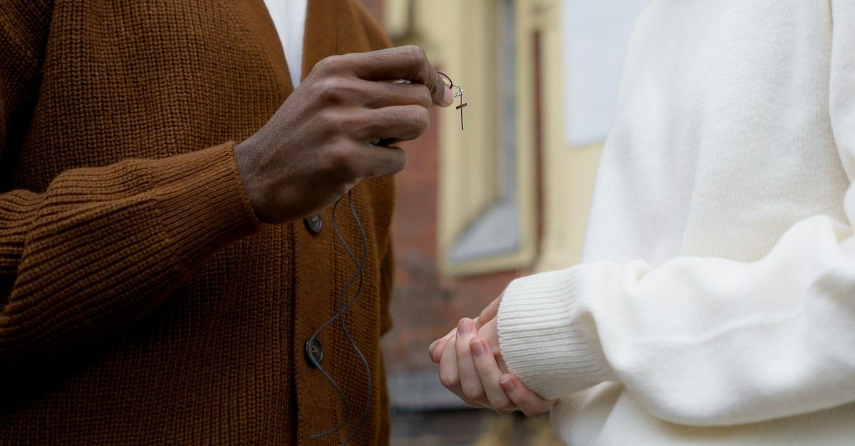 Man handing a woman a cross