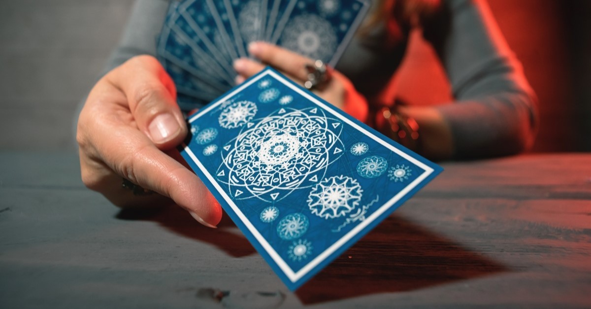 woman holding tarot card deck, where do tarot cards come from