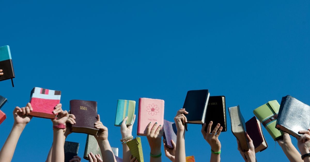 Friends holding up their Bibles
