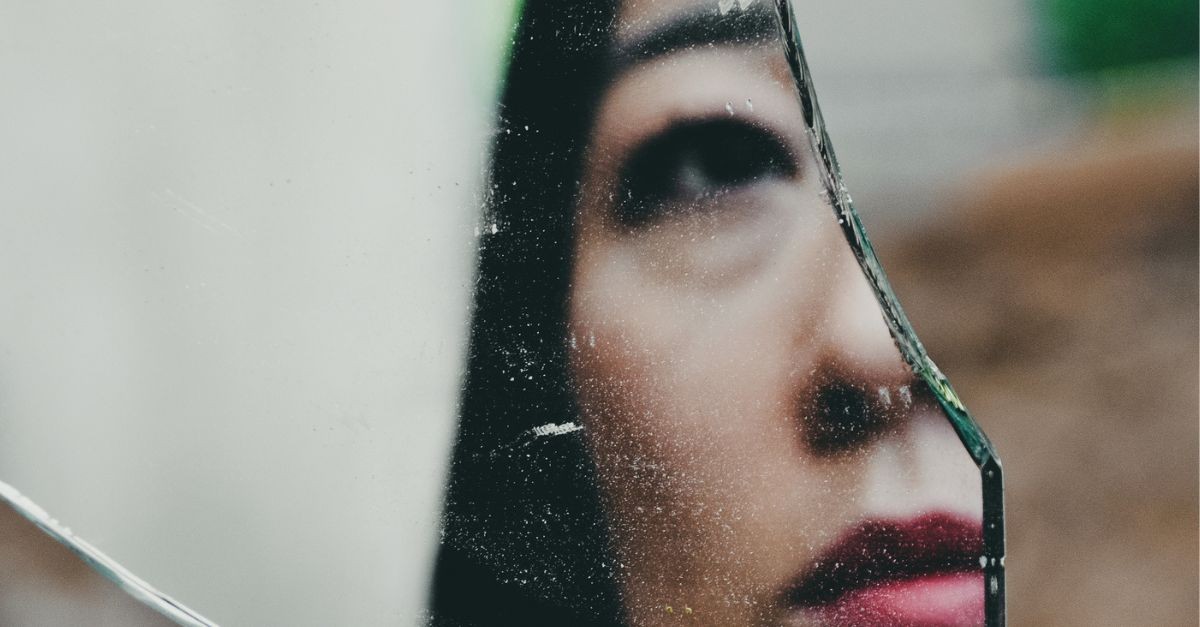 Woman Looking in a Broken Mirror